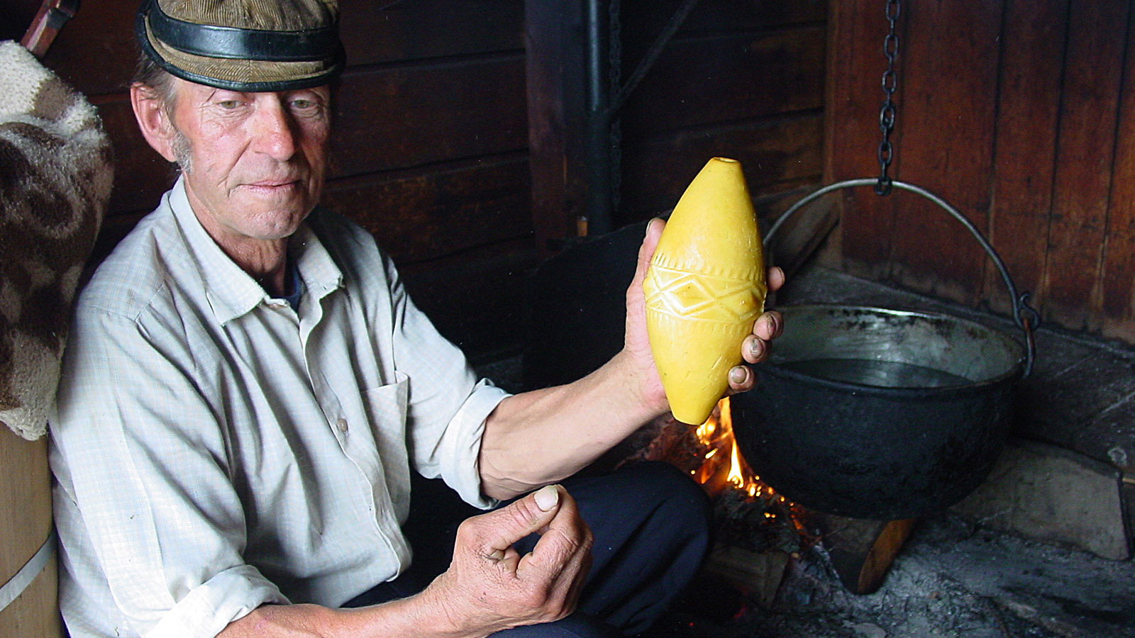 Hohe Tatra, Jan Urbas bei der Käsefertigung. In der Hand: der geräucherte Hartkäse aus Schafsmilch "Oscypek" - eine regionale Spezialität. Foto: Hilke Maunder 