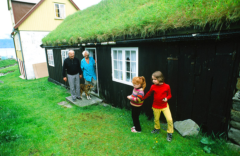 DK/Färöer/Esturoy: Gjóv, Familie vor traditionellem Wohnhaus